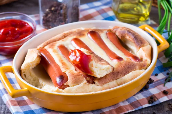 English food: toad in the hole into a baking dish on the table.