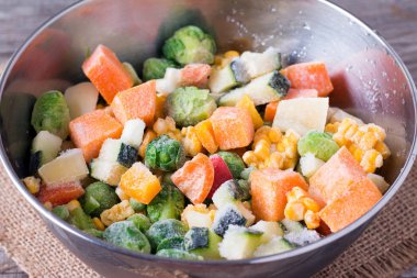 Ahşap masa arka plan üzerinde kase Dondurulmuş sebzeler.