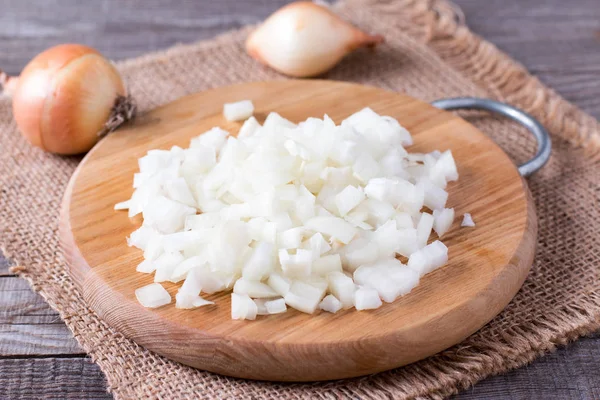 Raw onion, chopped very small cubes on a wooden board — Stock Photo, Image