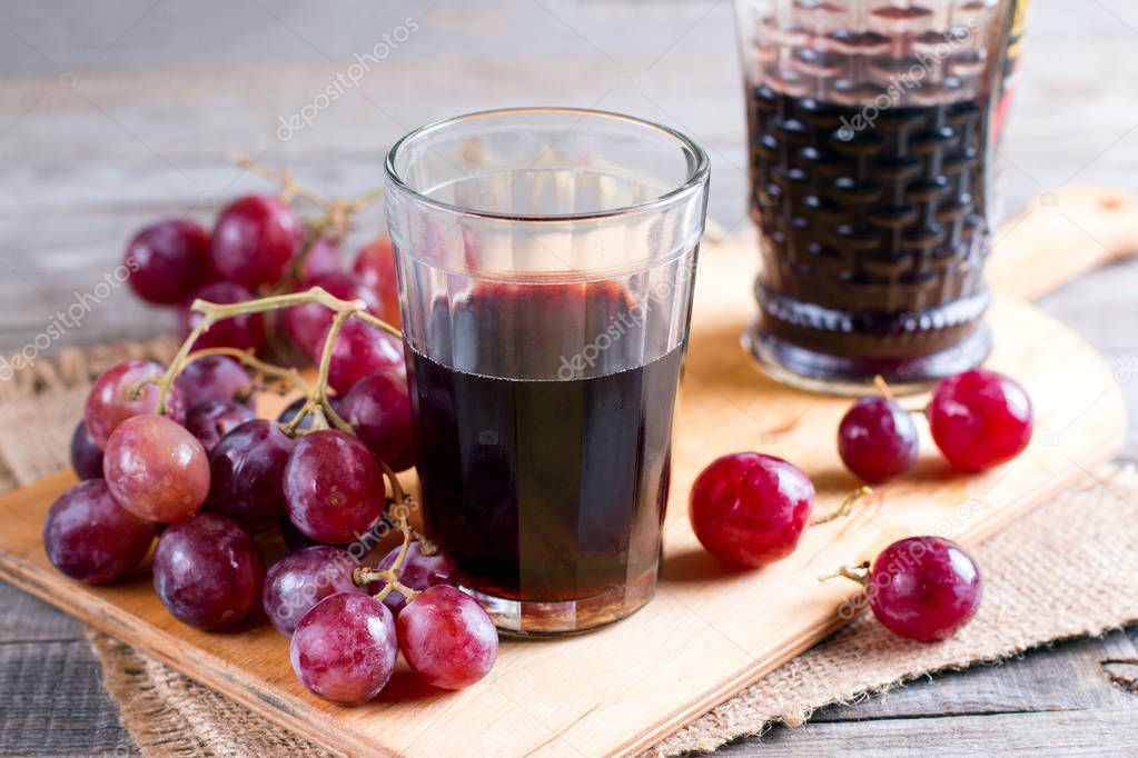 Glass of red wine and grapes on the table