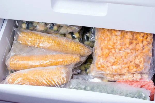 Frutas e legumes congelados em sacos no congelador, close-up — Fotografia de Stock