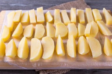 Dondurulmuş patates ahşap bir masa üzerinde bir kesme tahtası üzerinde