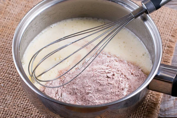 Mistura de cacau em pó, farinha e ovos batidos. Fazendo bolo de camada de chocolate — Fotografia de Stock