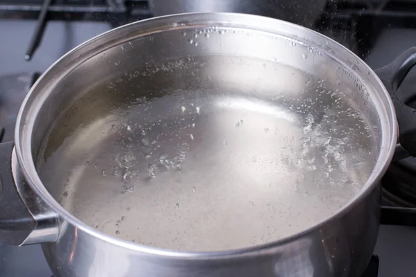 Boiling water in pan on stove in the kitchen — Stock Photo, Image