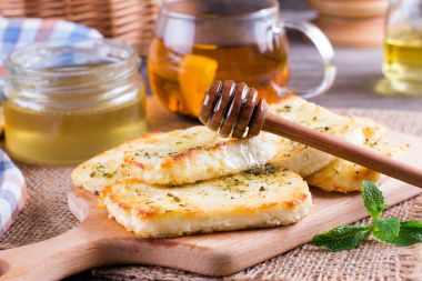 Bir kesme tahtası üzerinde otlar peynirli ızgara haloumi