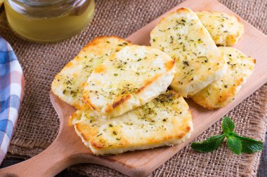 Bir kesme tahtası üzerinde otlar peynirli ızgara haloumi