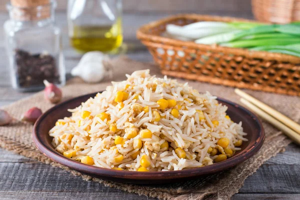 Arroz frito asiático com ovos e milho no prato em fundo de madeira — Fotografia de Stock