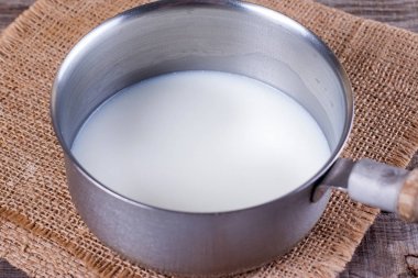 Milk in a saucepan clipart