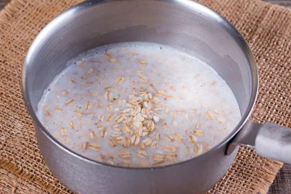 Cooking oatmeal porridge in a saucepan — Stock Photo, Image