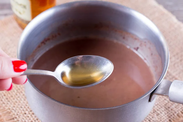 A spoon of cognac in cocoa — Stock Photo, Image