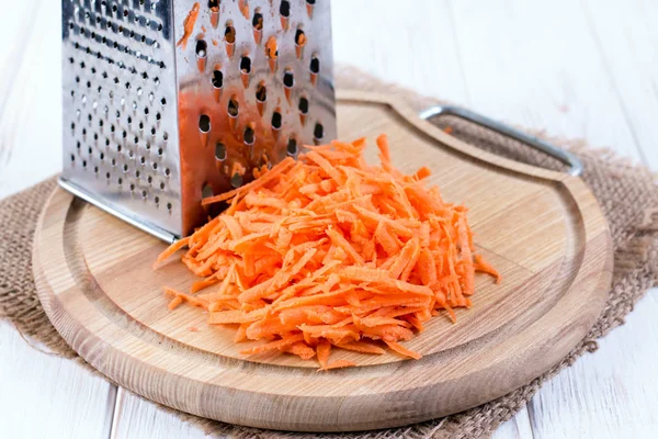 Geriebene Möhre auf einem hölzernen Hintergrund — Stockfoto