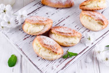 Ev yapımı çörekler ahşap arka plan üzerinde süzme peynir ile doldurulmuş