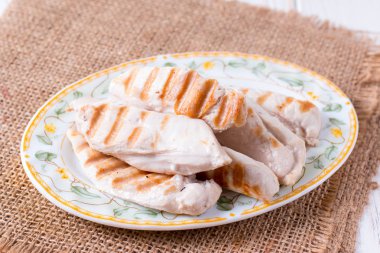 Bir kesme tahtası üzerinde ızgara tavuk fileto
