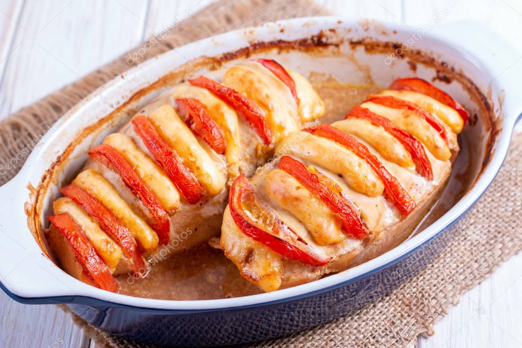 Chicken fillet baked with tomatoes and cheddar cheese
