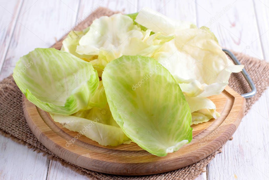 Ingredients for cooking cabbage rolls. Cabbage leaves on a cutting board