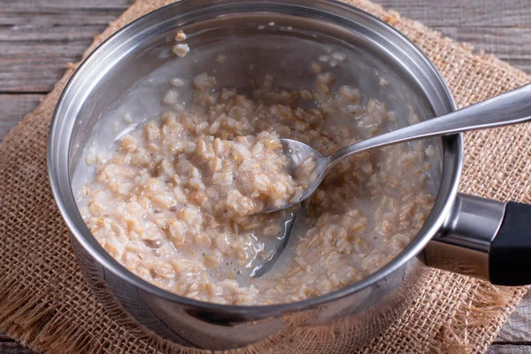 Oatmeal porridge in a saucepan