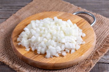 Sliced onions on a cutting board on a wooden background