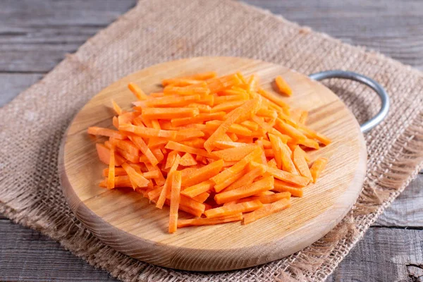 Sliced carrots on cutting board on wooden background — 스톡 사진