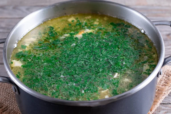 Cooking soup. Greens in a pot with soup — Stock Photo, Image