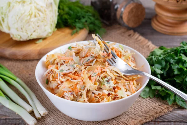 Salad with cabbage and carrots in a white plate — Stock Photo, Image