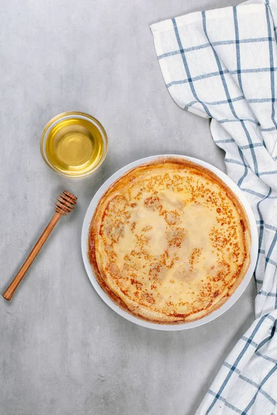 Тонкие блинчики на белой тарелке с медом — стоковое фото