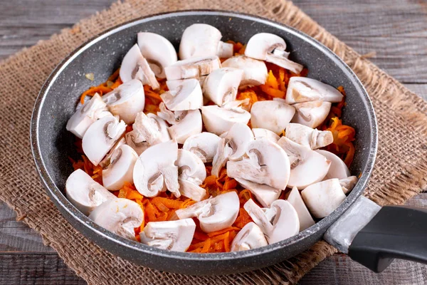 Cogumelos fritos com cebolas e cenouras na frigideira — Fotografia de Stock