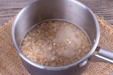 İçinde metal pot portre sağlıklı yulaf lapası yemek