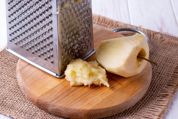 Rallador de metal y manzana en tabla de cortar — Foto de Stock