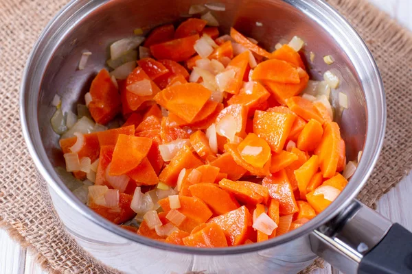 Тушкована морква з цибулею на металевій сковороді на столі — стокове фото