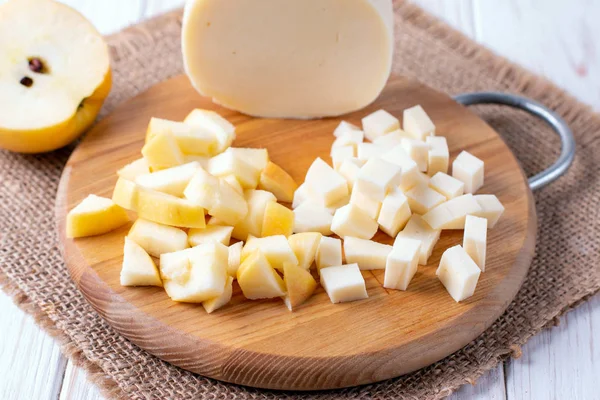 Сыр и яблоки на разделочной доске — стоковое фото