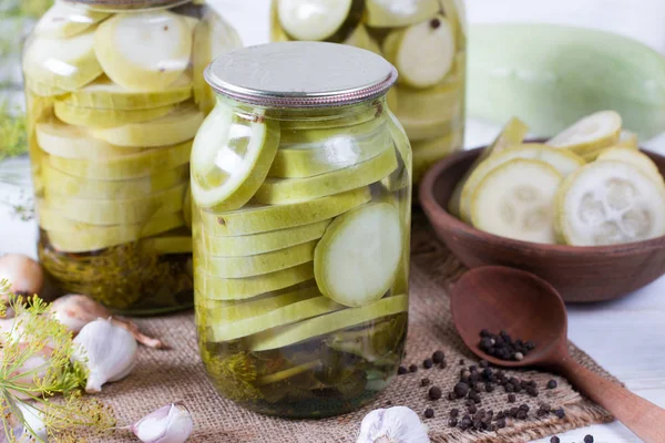 Pickled zucchini in glass jar on a wooden table — Stock Photo, Image