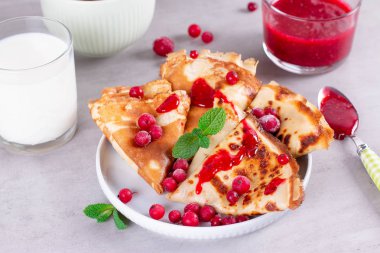 İnce krep ya da krep seramik tabakta reçel ve donmuş böğürtlen, nane