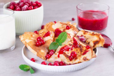 İnce krep ya da krep seramik tabakta reçel ve donmuş böğürtlen, nane