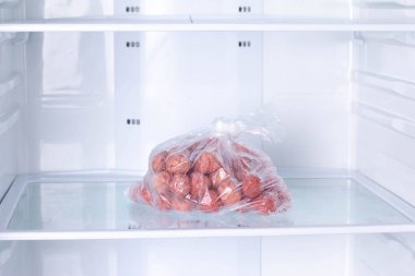 Frozen Meatballs in a plastic bag in refrigerator clipart