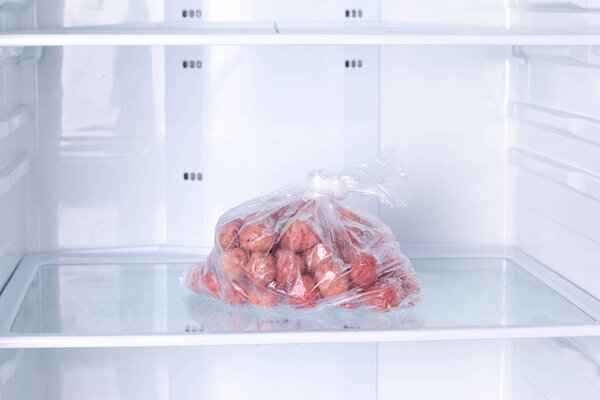 Frozen Meatballs in a plastic bag in refrigerator