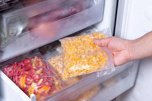 Man Putting Plastic Bag Corn Refrigerator Frozen Vegetables Closeup — Stock Photo, Image