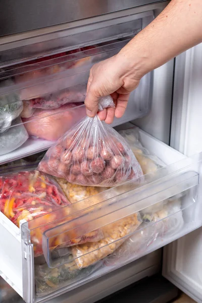 Man Putting Plastic Bag Meatballs Refrigerator Frozen Vegetables Closeup — Stock Photo, Image