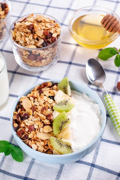 Granola with Greek yogurt kiwi and banana in a bowl with a spoon. Fitness diet for weight loss, proper and tasty food
