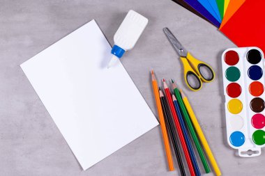 Masaya kağıt, yapıştırıcı ve makas koyun. Çocuk sanat projesi, çocuklar için bir zanaat. Çocuklar için el işi.