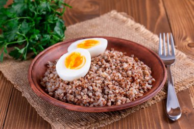 Ahşap masada haşlanmış yumurta ve karabuğday. Diyet menüsü.