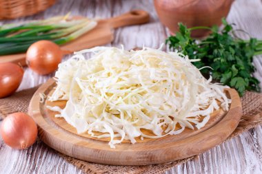 Masanın üzerinde bir kesme tahtası üzerinde lahana dilimlenmiş