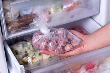 Buzdolabında dondurulmuş yiyecek var. Buzdolabında köfteli plastik poşet, yakın plan.