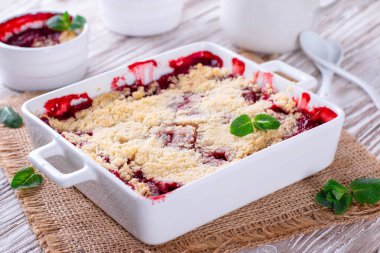 Böğürtlen, beyaz ahşap arka planda beyaz tabakta parçalanır.