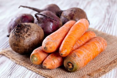 Tahta arka planda taze organik havuç ve pancar, seçici odak