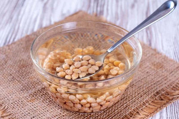 Ceci Acqua Una Ciotola Vetro Con Cucchiaio Tavolo Legno — Foto Stock