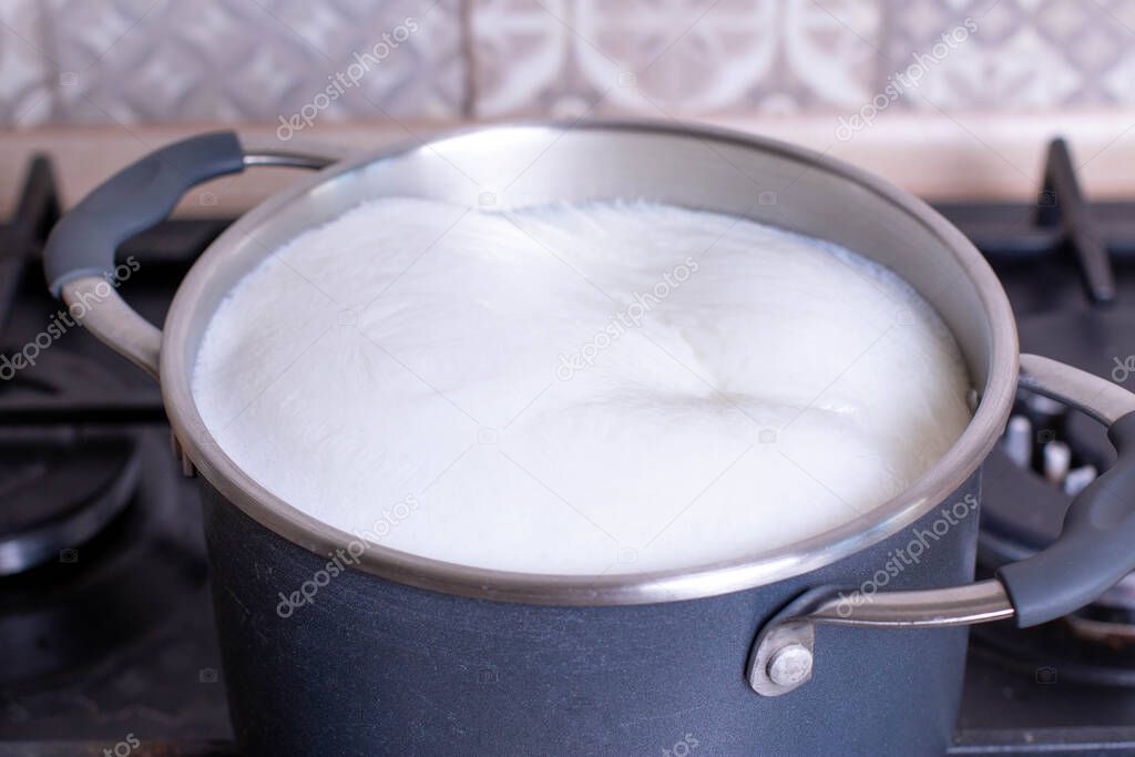 Milk boiling over a pan, closeup