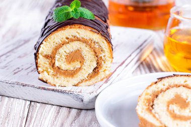 Tahta kesme tahtasına kremalı kek rulosu.