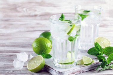 Soğuk yaz içeceği ve kokteyl. Taze mojito kokteyli, limon, buz ve naneli beyaz arka planda bir bardak.