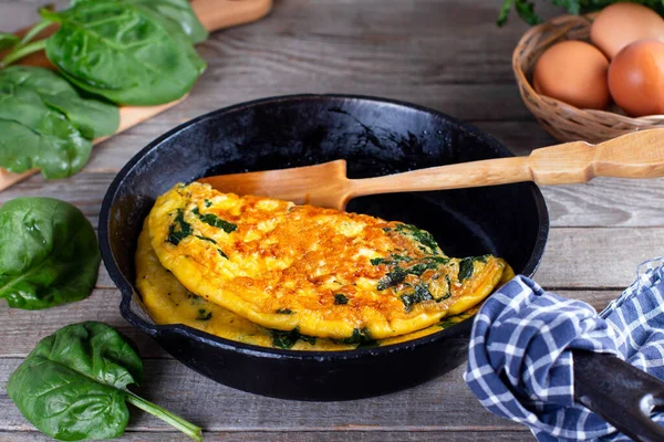 Omelette stuffed with spinach and cheese for a breakfast. Omelet with spinach leaves.