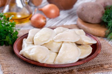 Hamur köfteleri, ahşap masada patates püresi ile dolu. Varenyky, vareniki - dolgulu börek